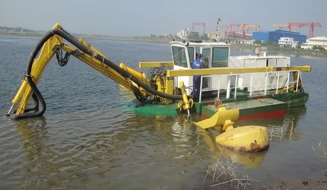 Pipeline river crossing with excavator and barge